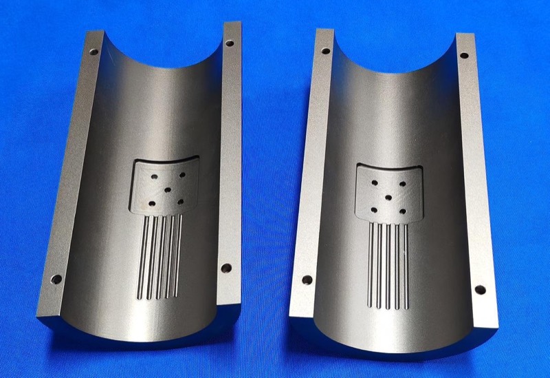 Grey anodised aluminium half-shells with milled slots — CNC machining