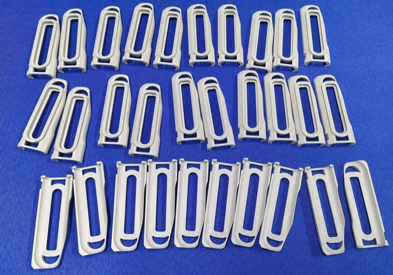 Light grey injection-moulded loop clips — Injection moulding